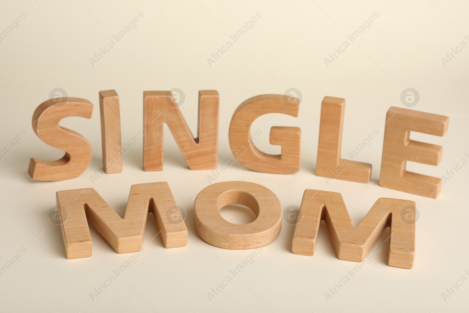 Photo of Words Single Mom made of wooden letters on beige background