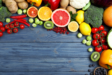 Fresh products rich in vitamin C on blue wooden table, flat lay. Space for text