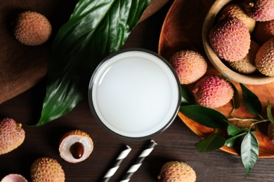 Photo of Fresh lychee juice and fruits on wooden table, flat lay