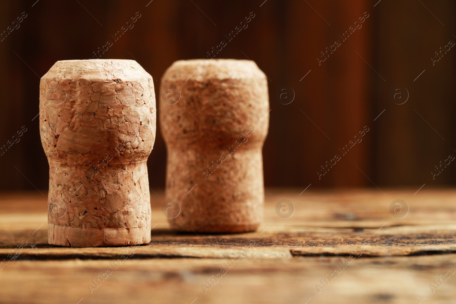 Photo of Corks of wine bottles on wooden table, closeup. Space for text