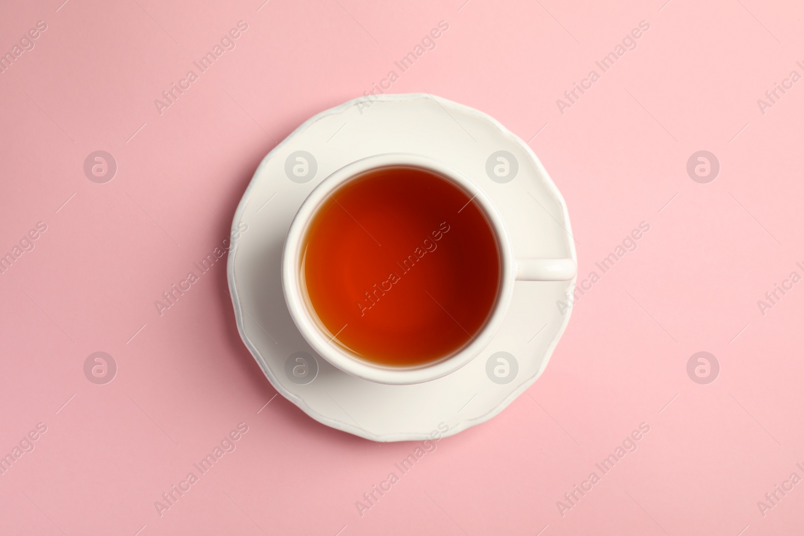 Photo of Cup of delicious tea with saucer on color background, top view