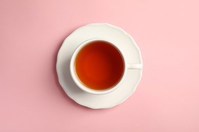 Photo of Cup of delicious tea with saucer on color background, top view