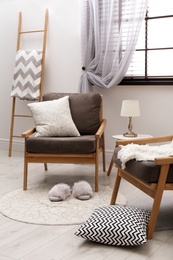 Cozy interior with armchairs, pillows and plaid near window