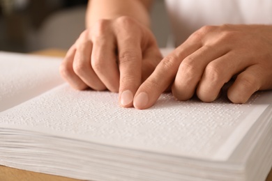 Photo of Blind man reading book written in Braille, closeup