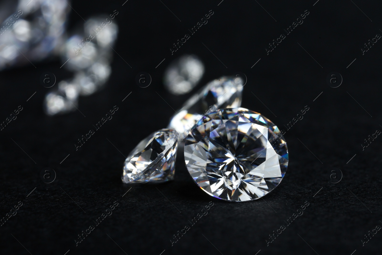 Photo of Many beautiful shiny diamonds on black background, closeup