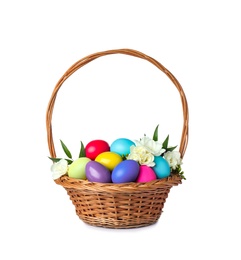 Photo of Wicker basket with bright painted Easter eggs and spring flowers on white background