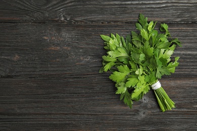 Photo of Bunch of fresh green parsley on wooden background, view from above. Space for text