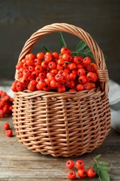 Fresh ripe rowan berries with green leaves on wooden table