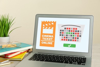 Image of Buying cinema tickets online. Laptop with open website or application on table
