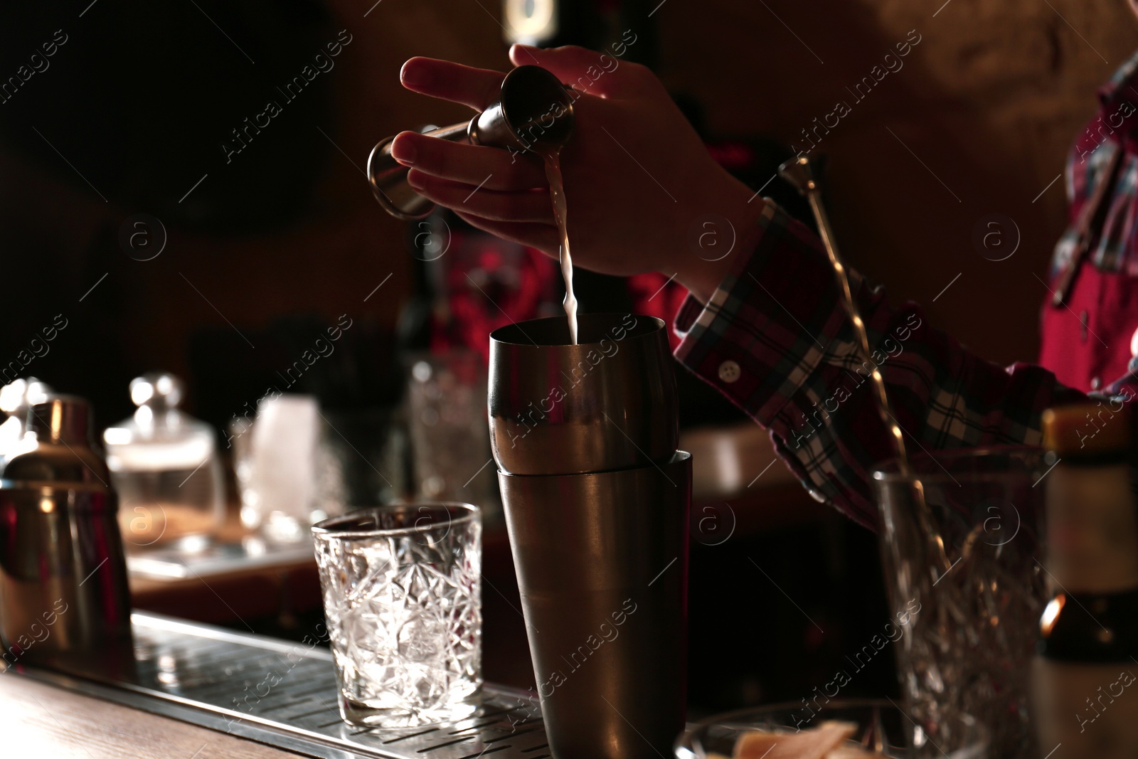 Photo of Bartender preparing fresh alcoholic cocktail at bar counter, closeup