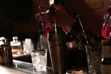 Photo of Bartender preparing fresh alcoholic cocktail at bar counter, closeup