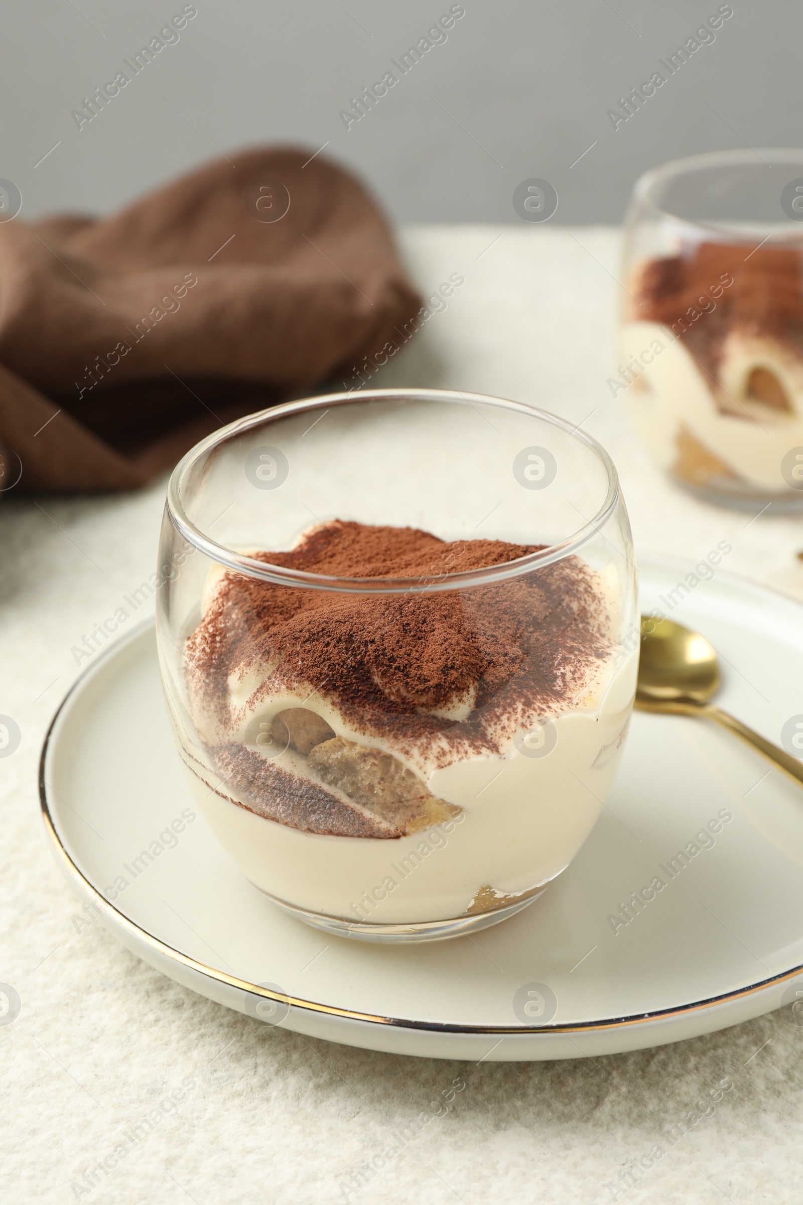 Photo of Delicious tiramisu in glasses on white table