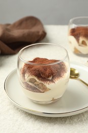 Delicious tiramisu in glasses on white table