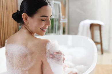 Photo of Beautiful young woman taking bubble bath at home