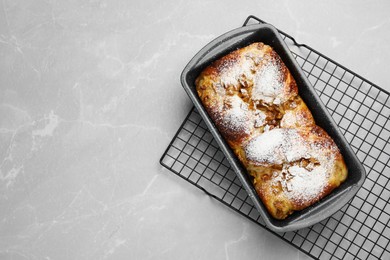 Delicious yeast dough cake in baking pan on marble table, top view. Space for text