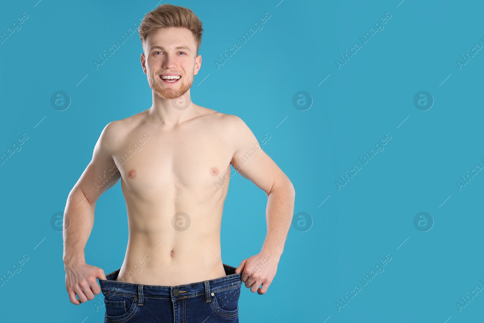 Photo of Handsome man in oversized jeans on color background. Space for text