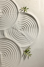 Photo of Beautiful spirals and branches on sand, top view. Zen garden