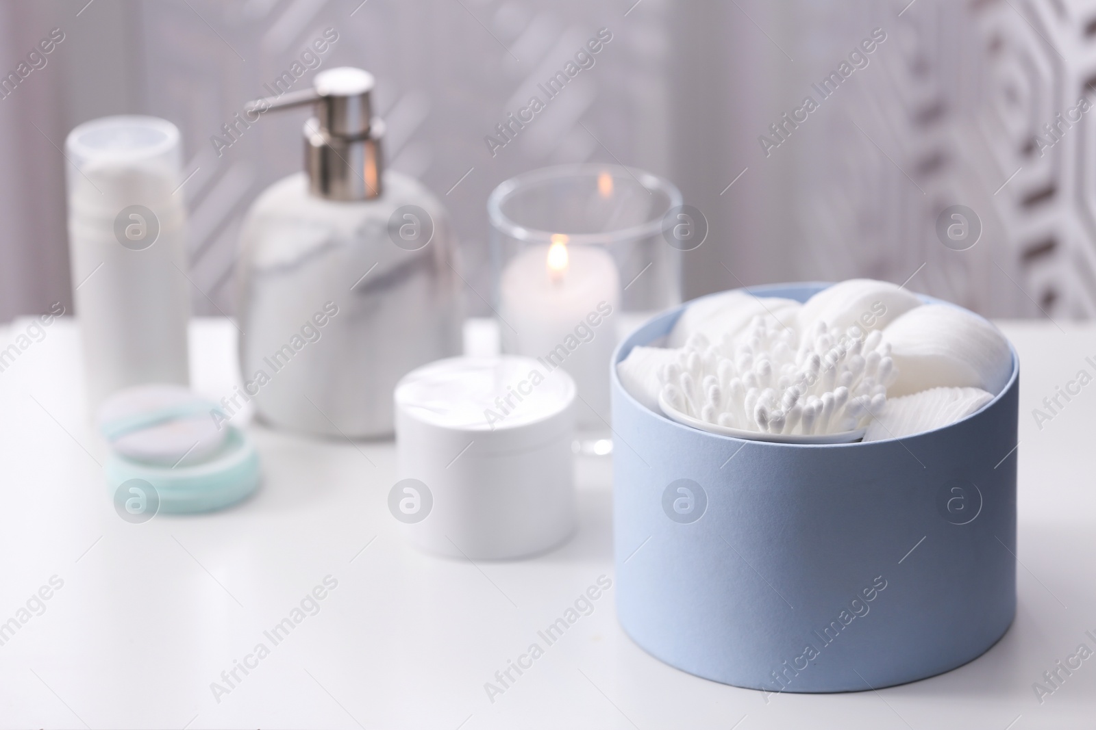 Photo of Cotton buds and pads in box on white table indoors, space for text