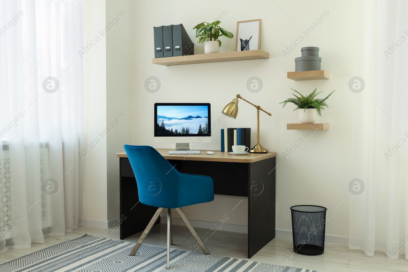 Photo of Cozy workspace with computer on wooden desk and comfortable chair at home