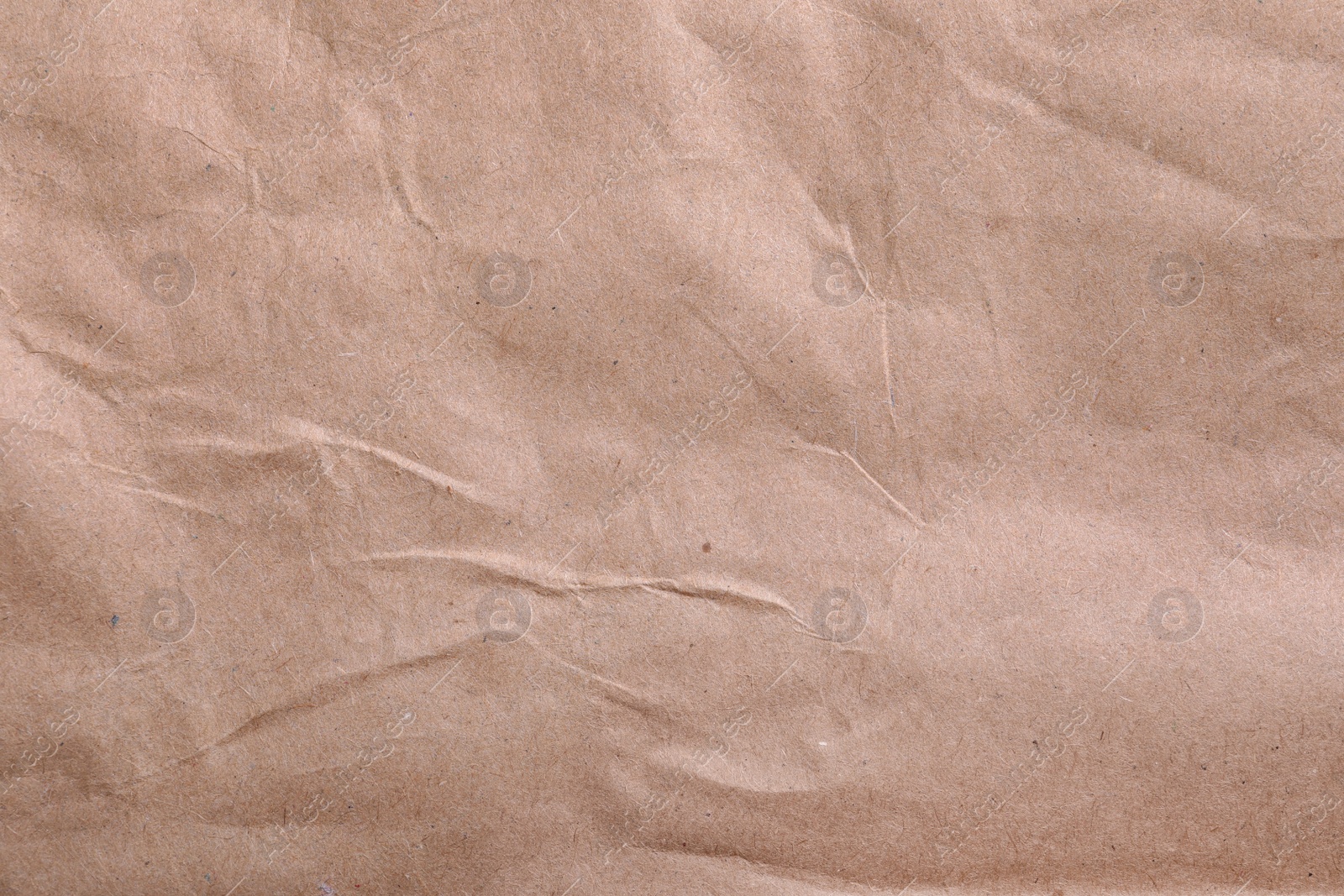 Photo of Texture of wrinkled kraft paper bag as background, closeup