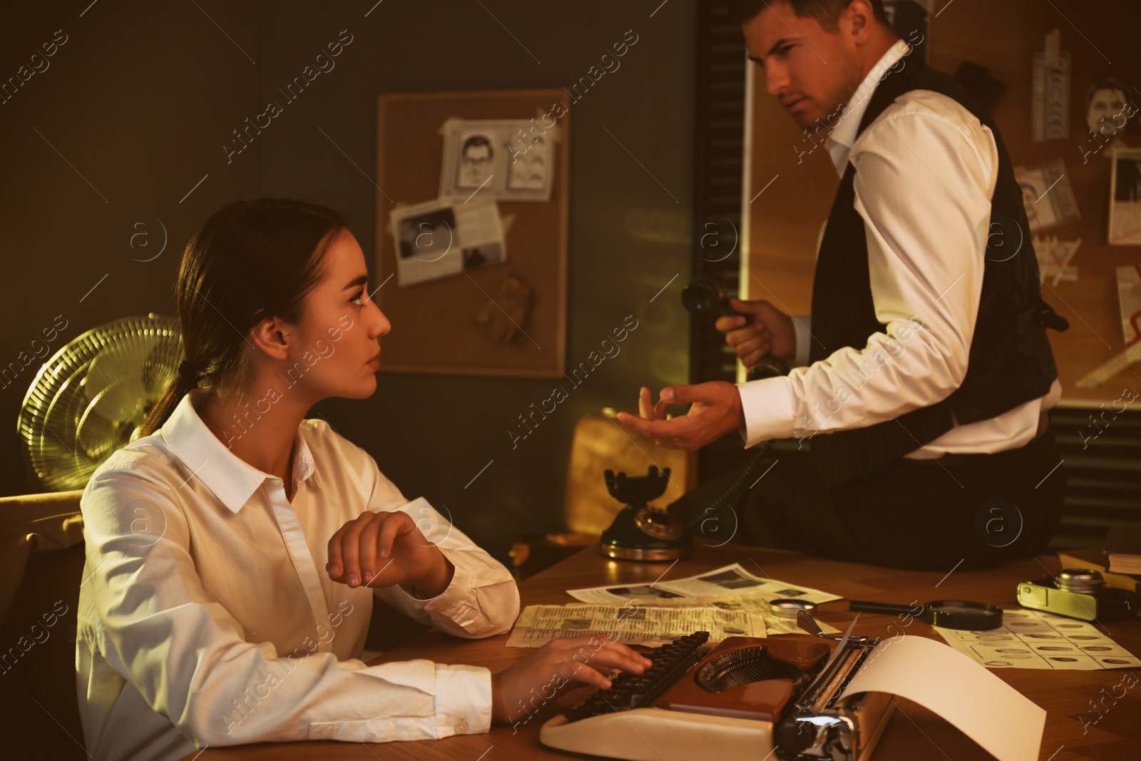 Photo of Old fashioned detective and her colleague working in office
