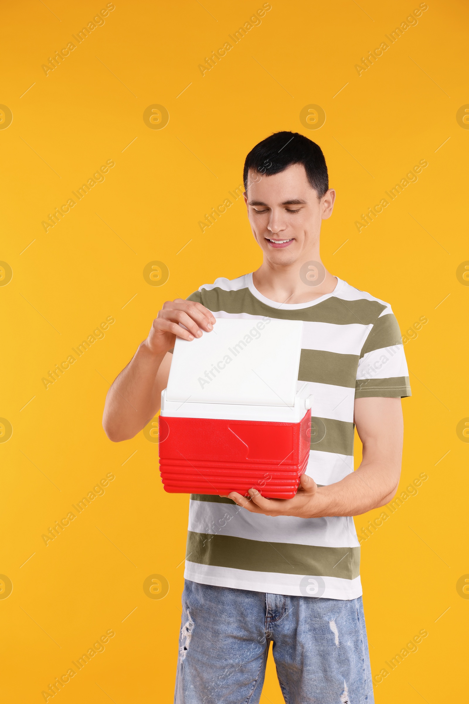 Photo of Man with red cool box on orange background