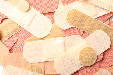 Photo of Different medical sticking plasters as background, closeup. First aid item