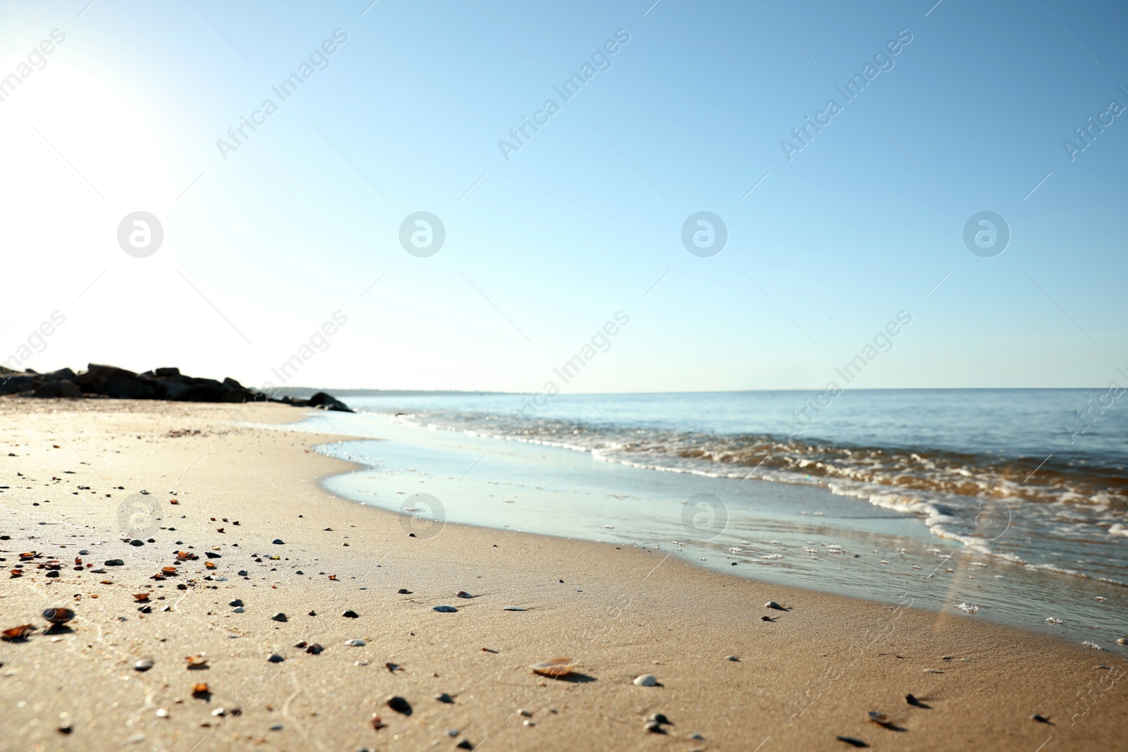 Photo of Beautiful sandy beach and sea under blue sky, closeup