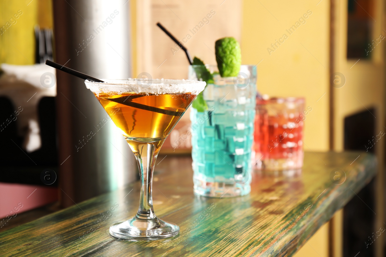 Photo of Glasses with delicious cocktails on counter in bar
