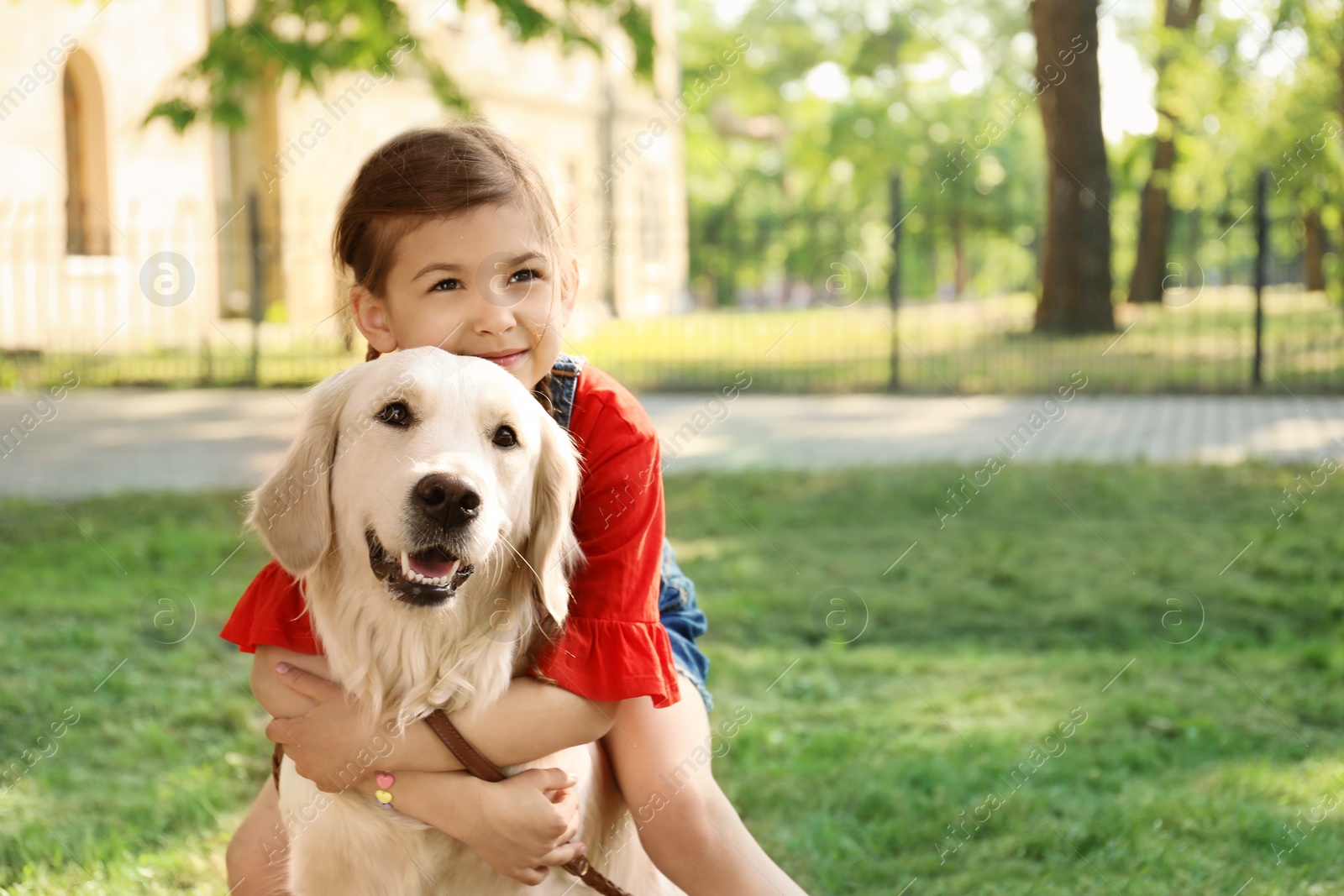 Photo of Cute little child with his pet in green park