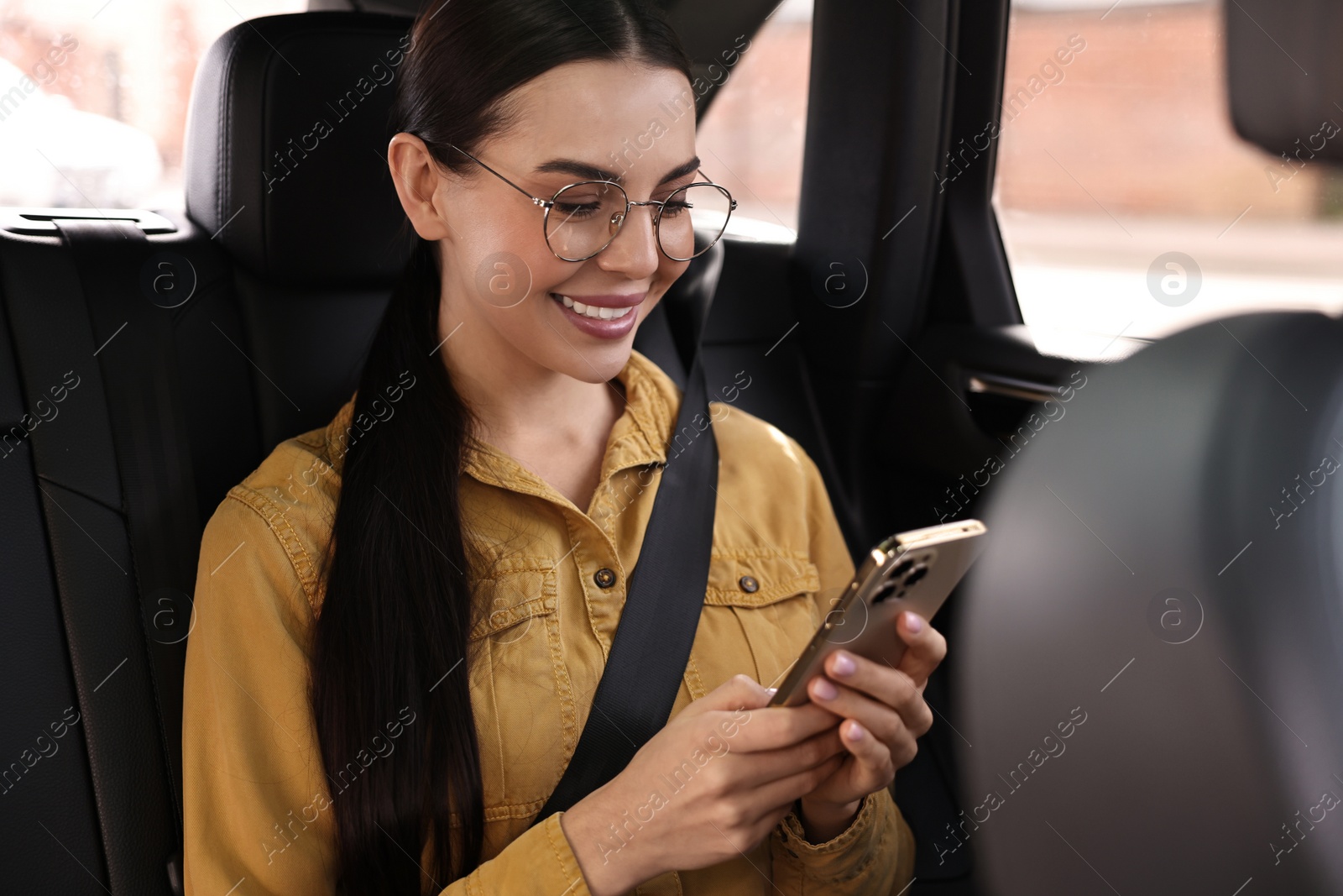 Photo of Woman with seatbelt using phone inside car