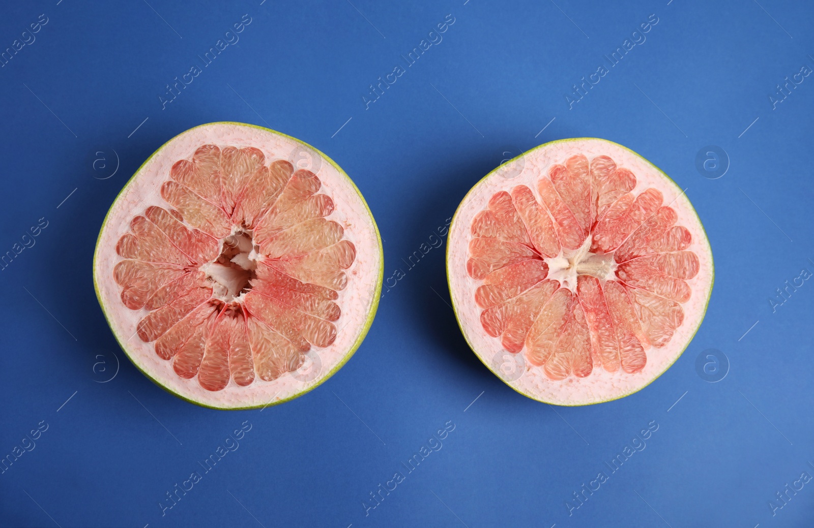 Photo of Fresh cut pomelo fruit on blue background, flat lay