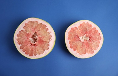 Photo of Fresh cut pomelo fruit on blue background, flat lay