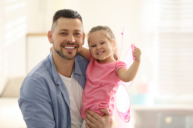 Photo of Father playing with his child at home