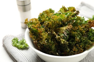 Tasty baked kale chips in bowl, closeup