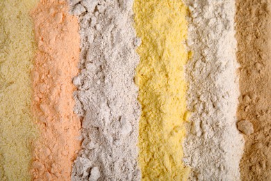 Different types of flours as background, top view