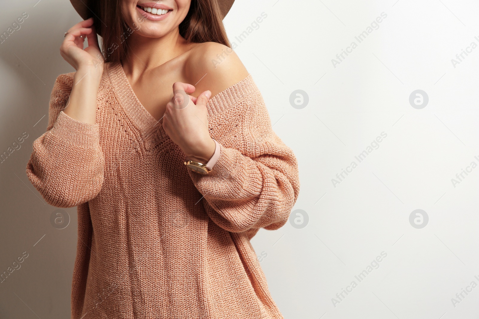 Photo of Beautiful young woman in warm sweater on white background. Space for text