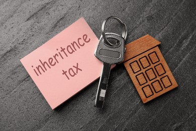 Inheritance Tax. Paper note and key with key chain in shape of house on grey table, flat lay