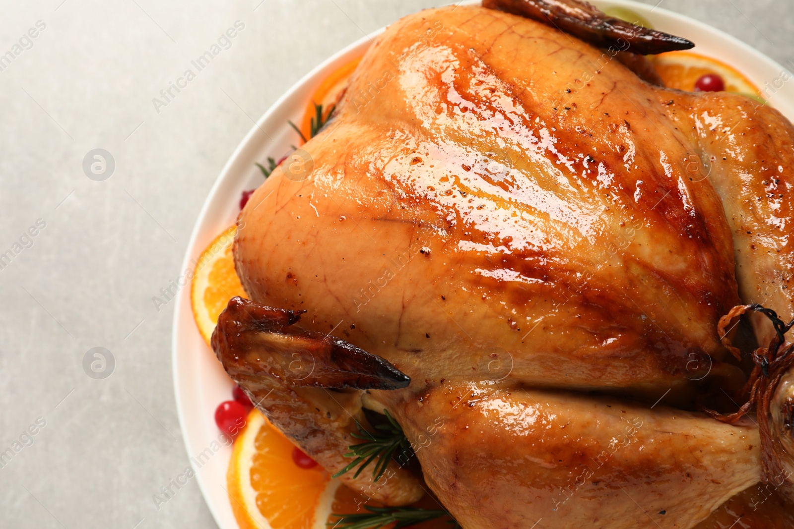 Photo of Platter of cooked turkey with garnish on grey background, closeup