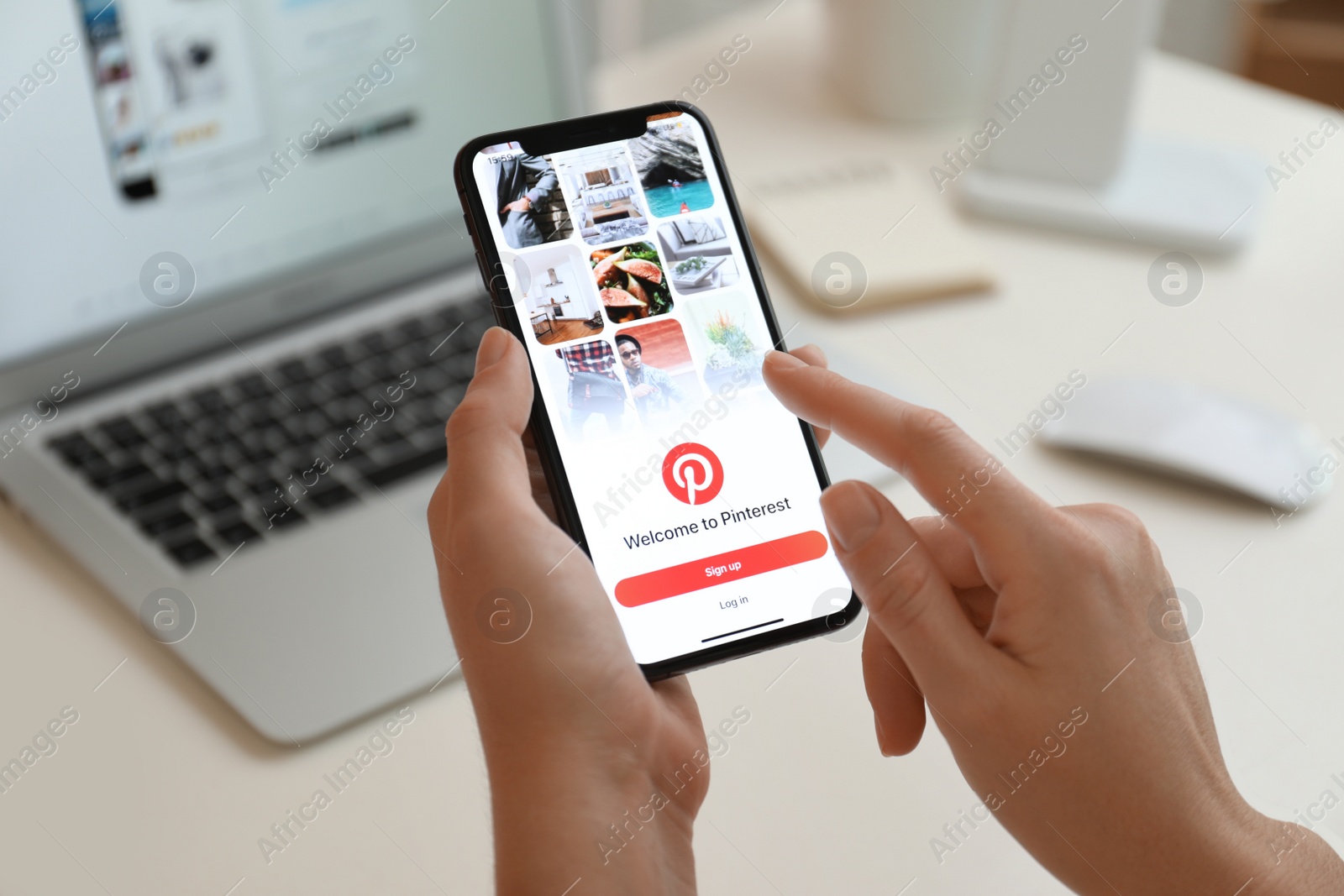 Photo of MYKOLAIV, UKRAINE - AUGUST 28, 2020: Woman holding iPhone 11 with Pinterest app on screen at table, closeup