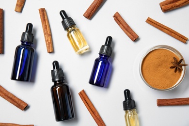 Photo of Flat lay composition with cinnamon essential oil on white background