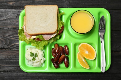 Tray with healthy food for school child on wooden background, top view