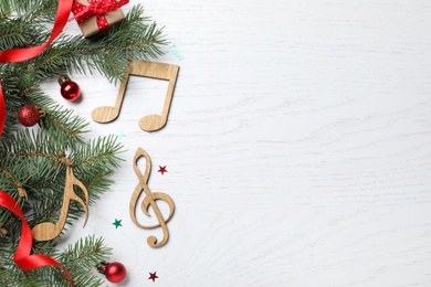 Photo of Flat lay composition with music notes on white wooden background, space for text. Christmas celebration