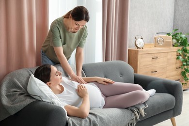 Doula taking care of pregnant woman at home. Preparation for child birth