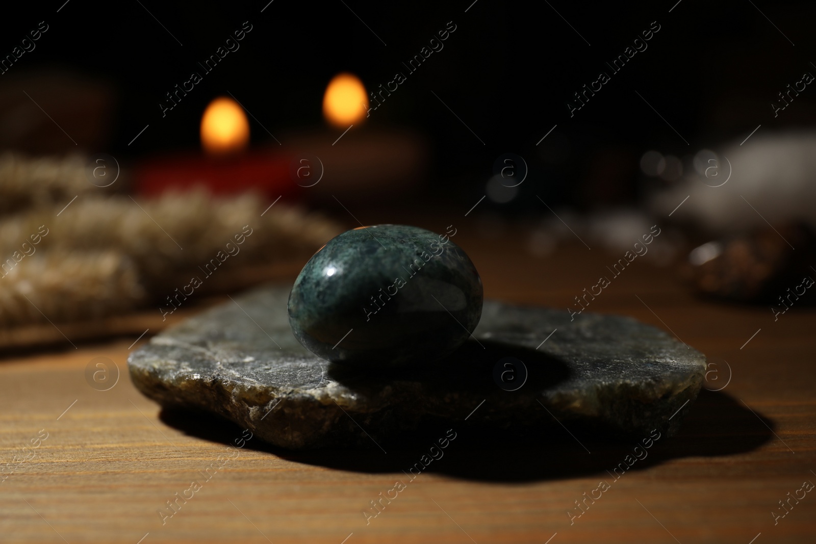 Photo of Healing gemstone on wooden table against blurred background