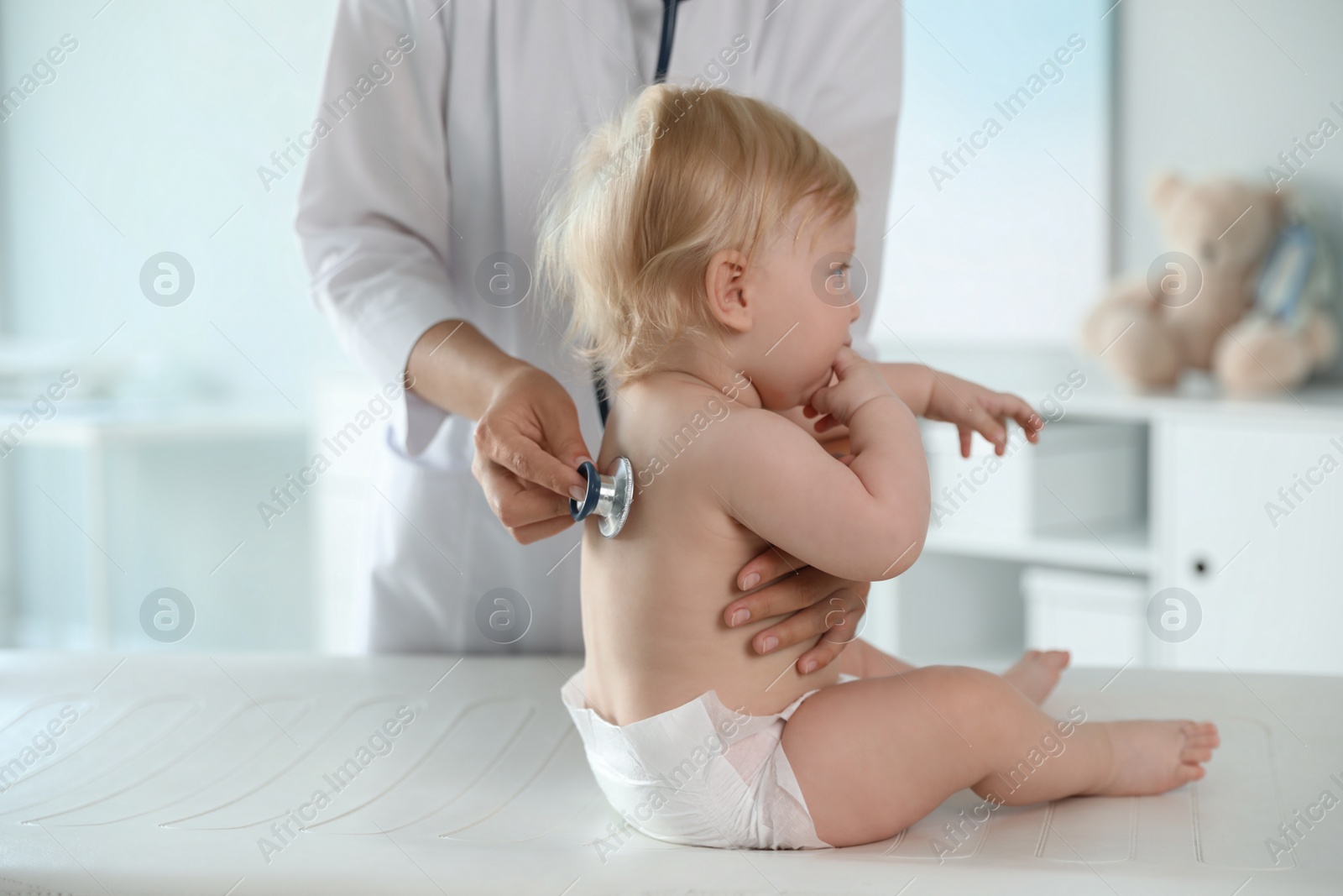 Photo of Pediatrician examining baby with stethoscope in hospital. Health care