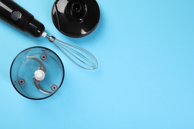 Photo of Hand blender kit. Whisk, lid, bowl and bowl chopper on light blue background, flat lay. Space for text