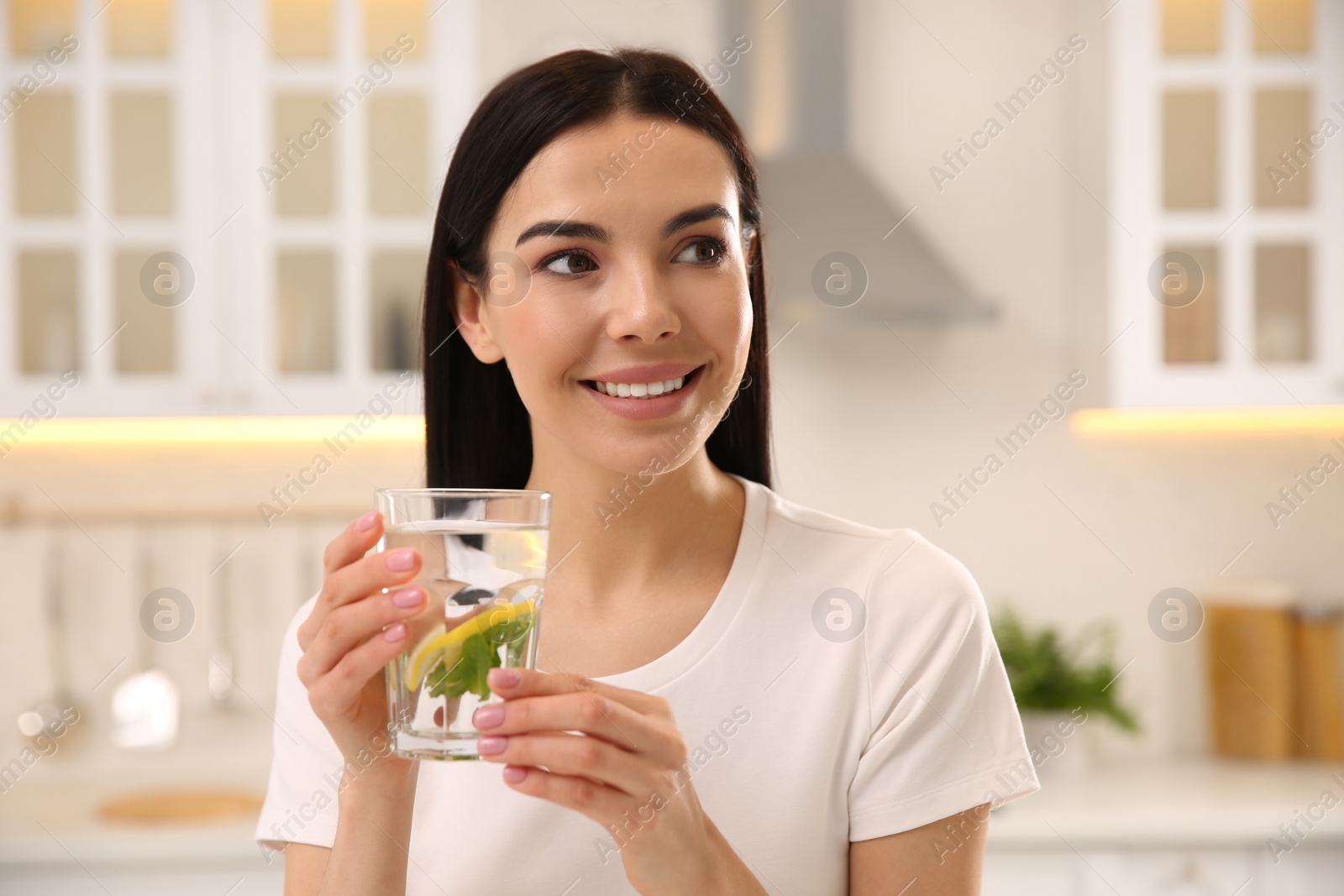 Photo of Young woman with glass of fresh lemonade at home