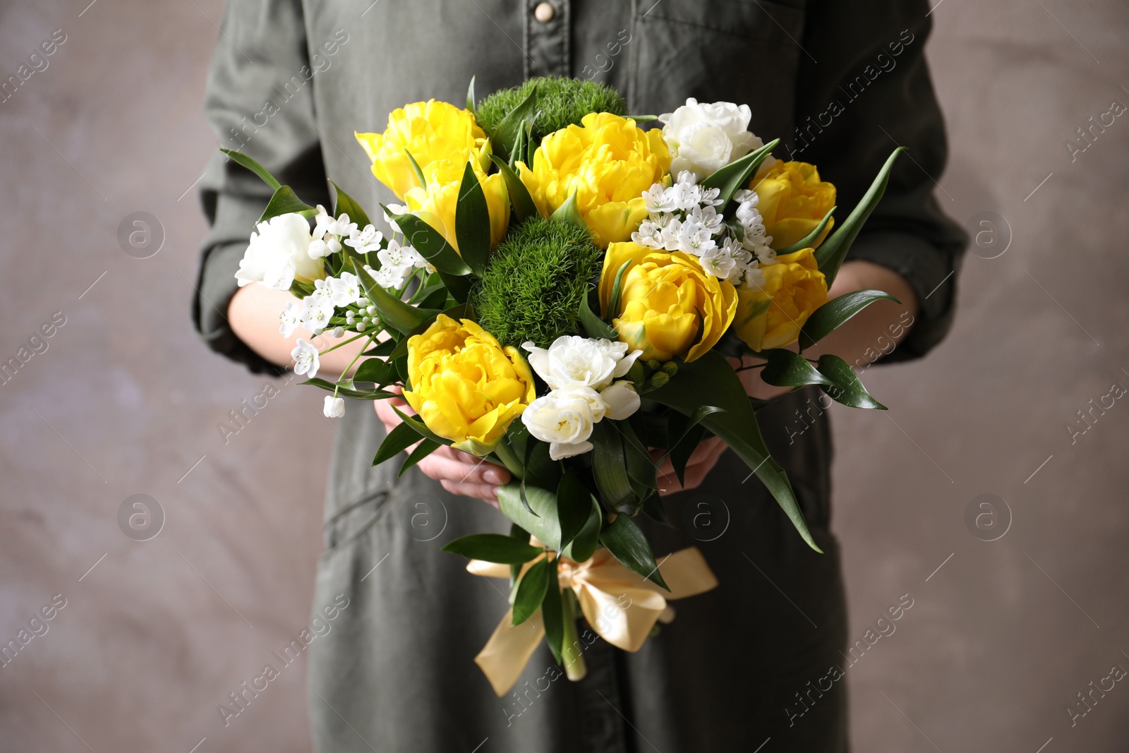 Photo of Woman with bouquet of beautiful peony tulips on beige background, closeup