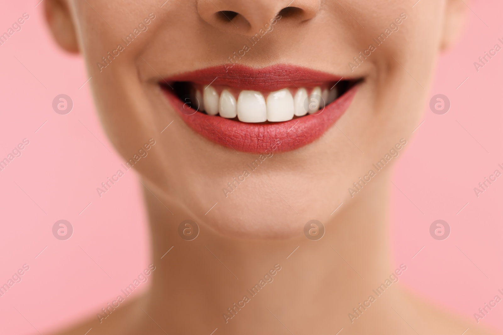 Photo of Woman with beautiful lips smiling on pink background, closeup